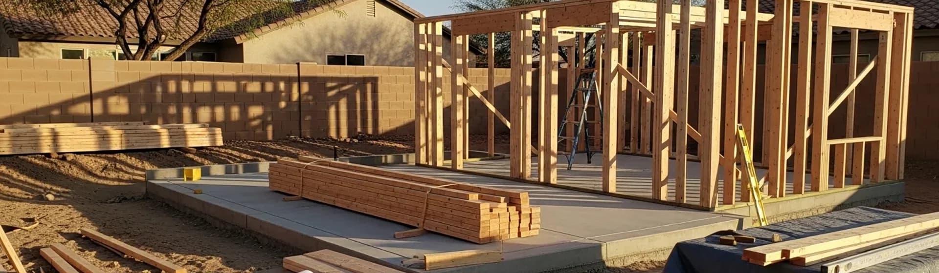 Wood framing for a detached casita on a concrete slab in a residential backyard.