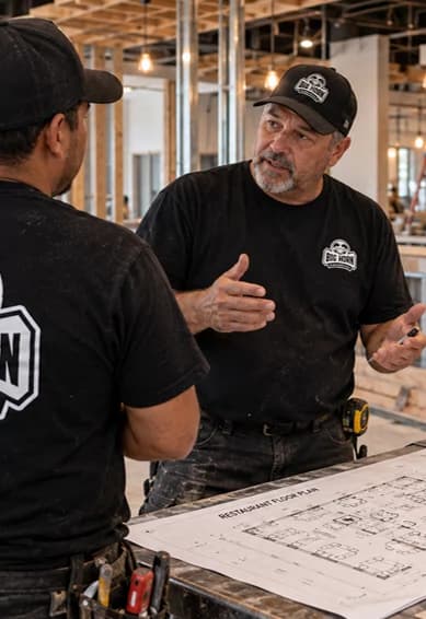 Two Big Horn team members discussing construction plans at a commercial job site.