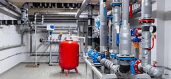 Shared building piping with water pumps, valves and a red expansion tank.