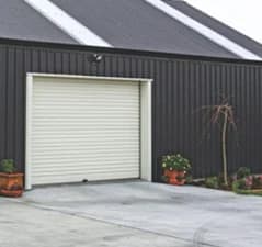 Detached garage exterior with a closed white garage door and driveway.