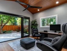 Flexible home office and lounge area with a desk, seating, and sliding glass doors.