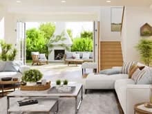 Light-filled living room with seating, a fireplace, patio doors, and an open staircase.
