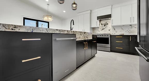 Two-tone fully custom kitchen cabinets with waterfall island and slab backsplash