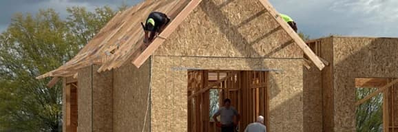 Crew framing the roof and walls of a detached accessory structure.