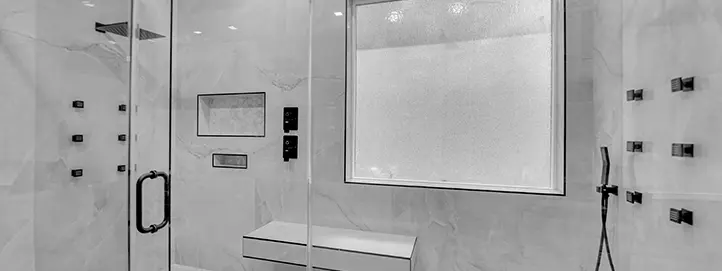 Wet room shower remodel in Summerlin with slab-style tile glass enclosure bench niche and matte black fixtures