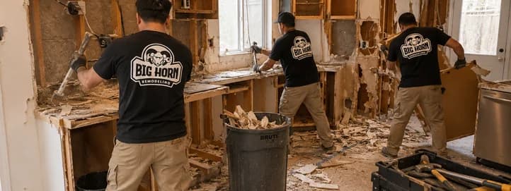 Kitchen demolition crew removing cabinets, drywall, and countertops during the demolition phase of a full residential kitchen remodel