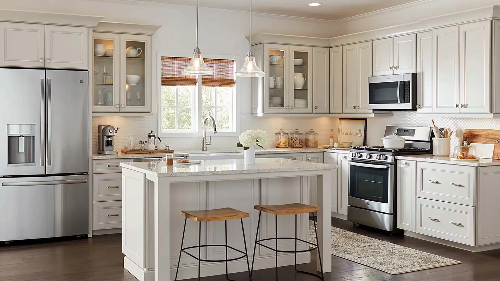 Finished Las Vegas kitchen remodel with white cabinets, island seating, pendant lights, and stainless appliances
