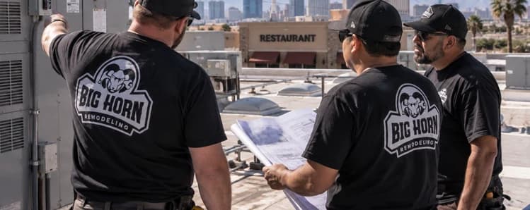 Three Big Horn Remodeling crew members inspect rooftop HVAC equipment while reviewing plans above a restaurant site.