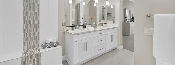 Bright bathroom remodel with white double vanity, mosaic tile detail, mirrors, and wall sconces