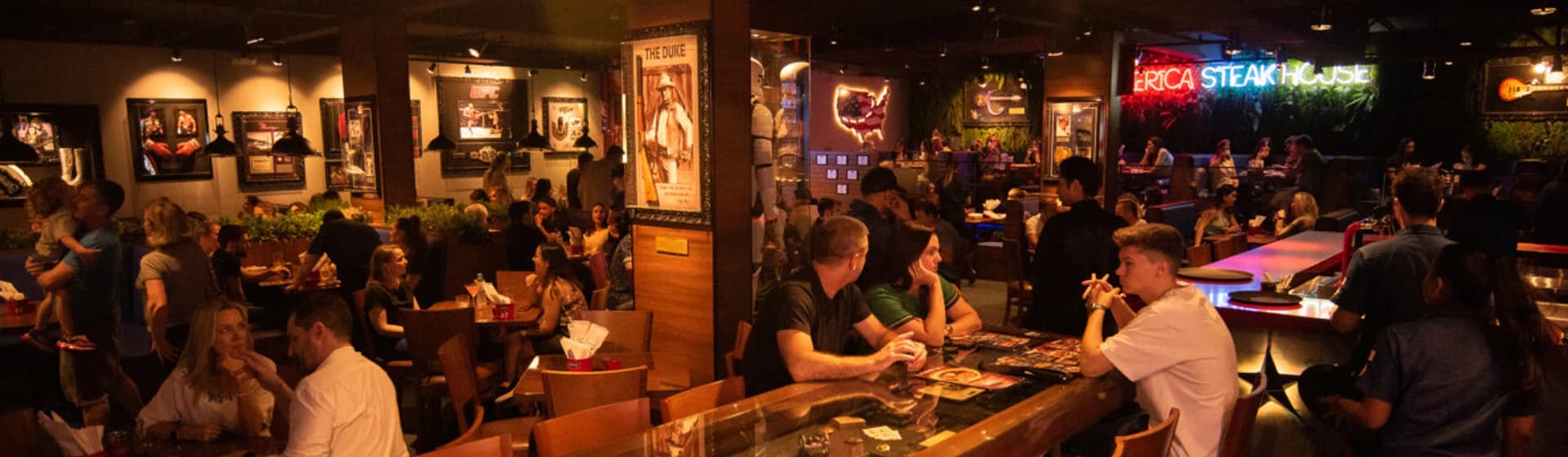 Crowded restaurant dining room and bar with warm pendant lighting