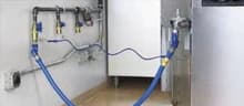 Gas and utility connections behind commercial kitchen equipment