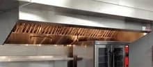Commercial kitchen exhaust hood above cooking equipment