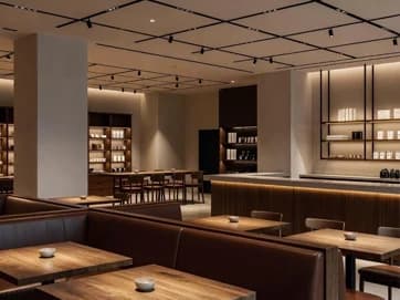 Commercial interior with columns, a long counter and ceiling track lights.