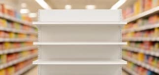 Empty white merchandise display shelves with stocked grocery aisles in the background.