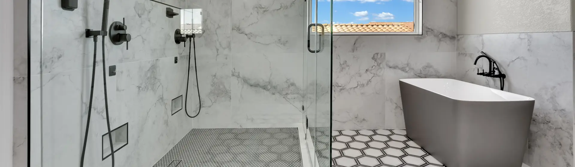 Finished marble-look shower with black fixtures and a freestanding tub