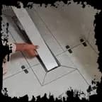 Installer aligning a linear shower drain with floor tile