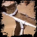 PVC shower drain plumbing rough-in beneath an opened shower floor