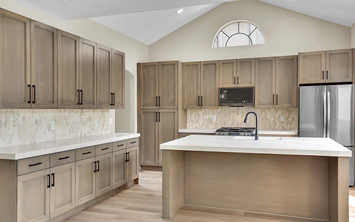 Front view of custom maple cabinet walls and freestanding Briella Gold quartz island in Cantabria kitchen