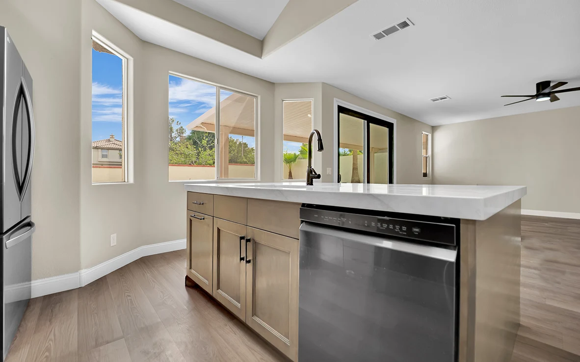 Dishwasher side of Cantabria kitchen island opening toward the adjoining living area