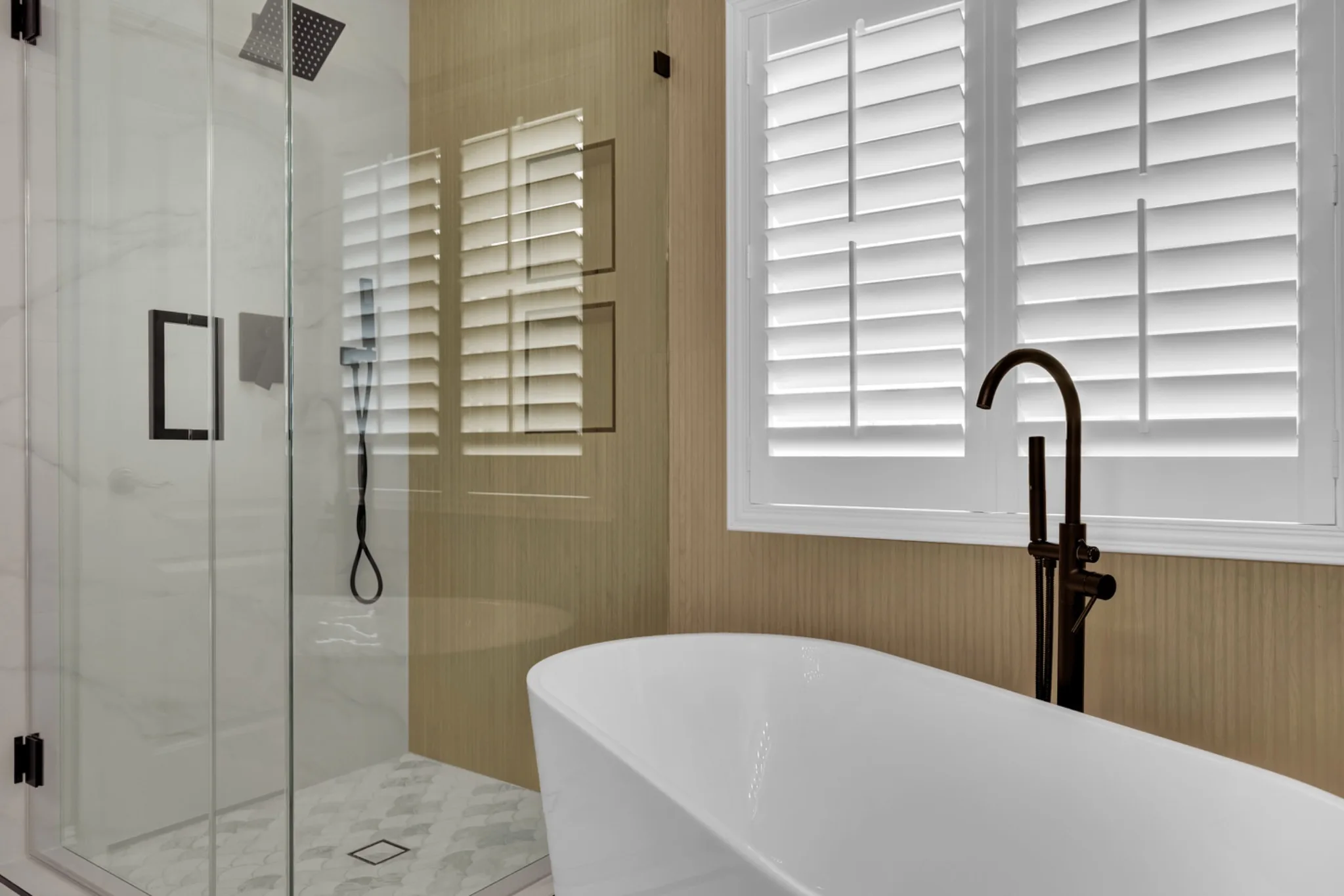 Custom 3/8-inch frameless glass shower enclosure beside freestanding tub in a primary bathroom remodel