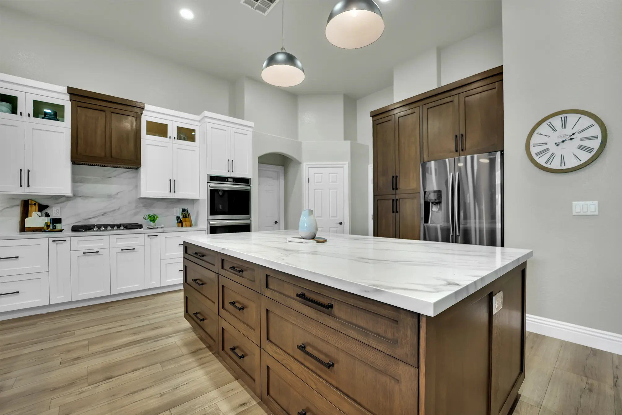 Custom Centennial Hills kitchen island with white oak cabinetry, refrigerator wall, LVP flooring, and pendant lighting