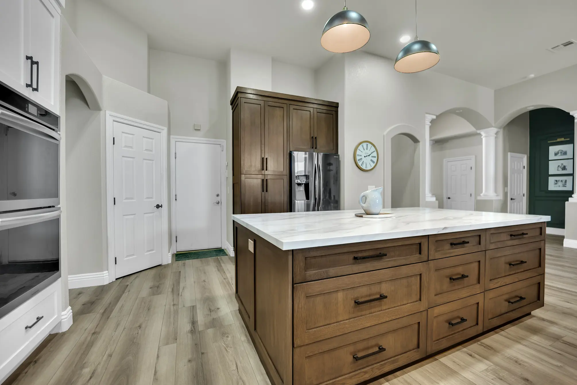 Centennial Hills custom kitchen remodel with LVP flooring, custom island storage, refrigerator wall, and arched openings