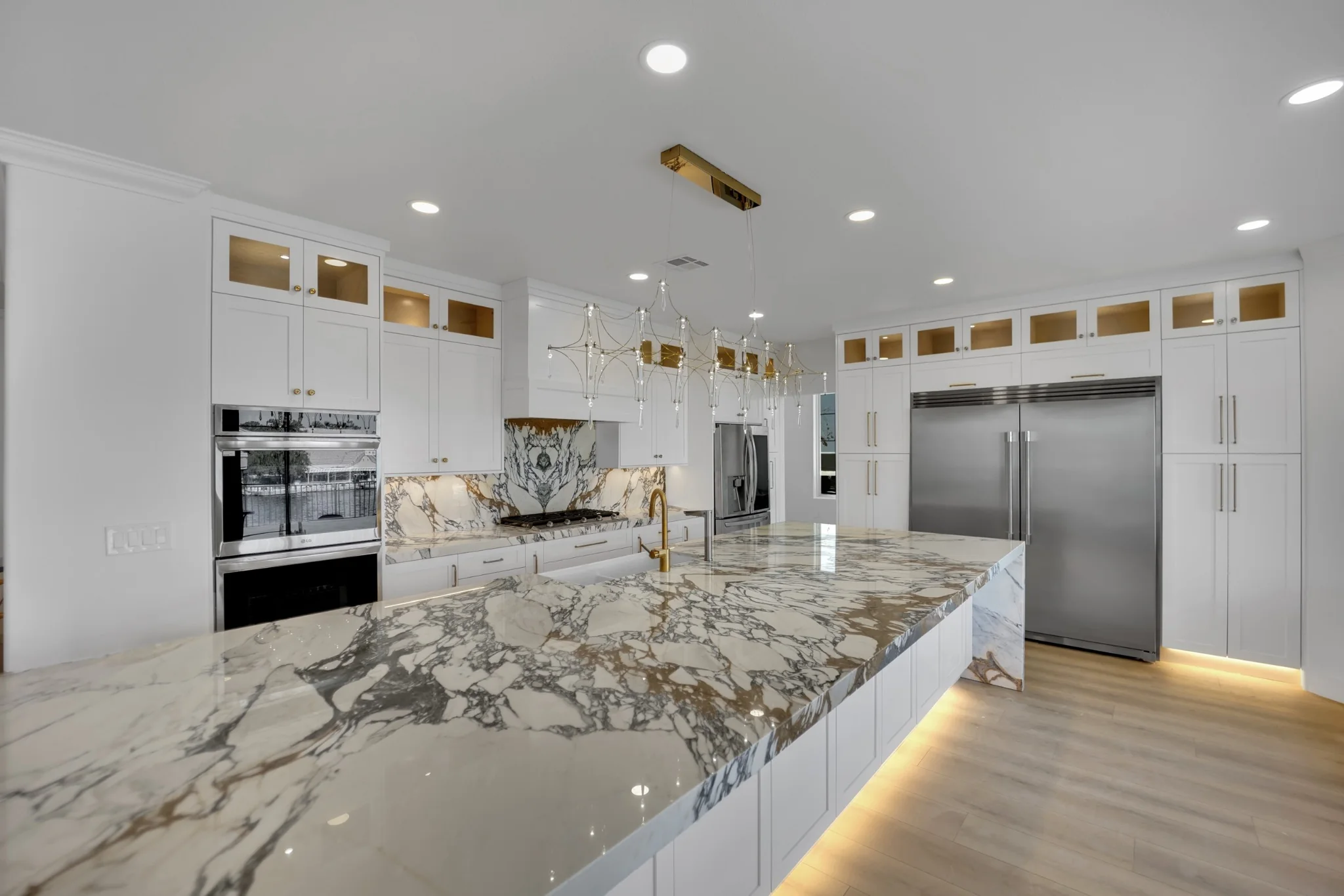 Desert Shores luxury kitchen remodel with custom white shaker cabinets, 12-foot island, marble, and integrated appliance walls