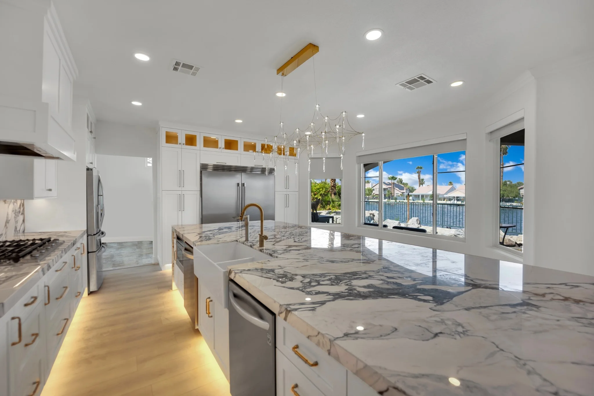 Desert Shores kitchen remodel with a Calacatta Violet marble island, custom white cabinetry, and waterfront views