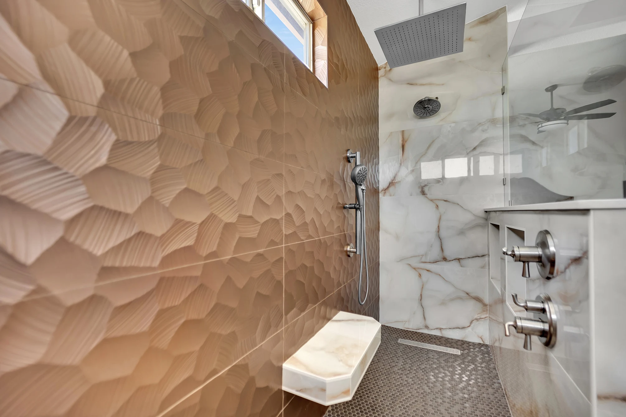 Kohler ceiling rainhead, wall showerhead and handheld above a floating seat, penny mosaic floor and linear drain.