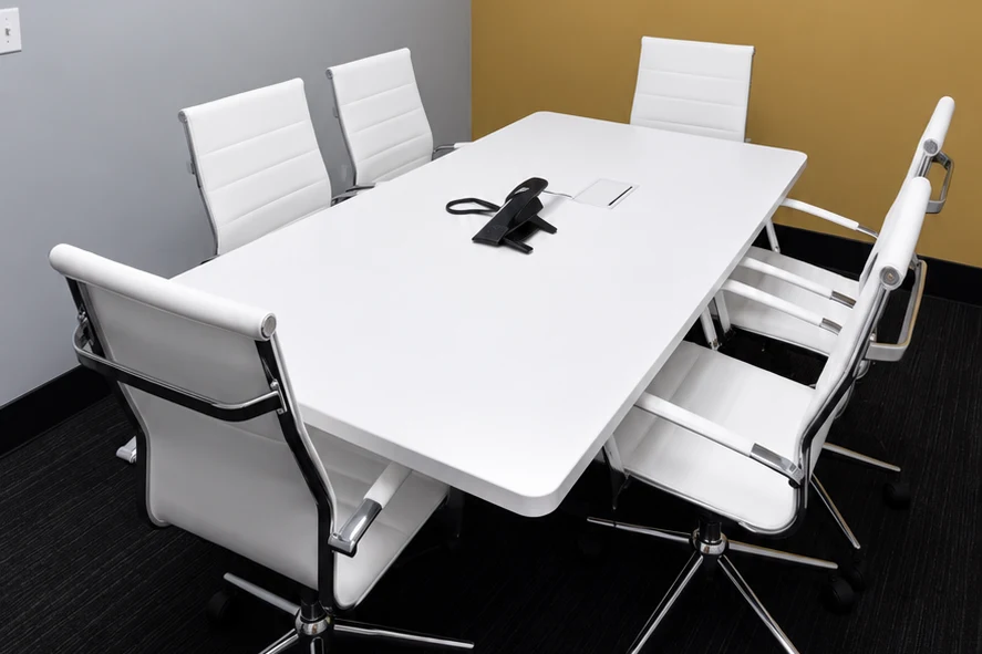 Ladah Law conference room with dark carpet, a white meeting table, and a gold-colored accent wall.