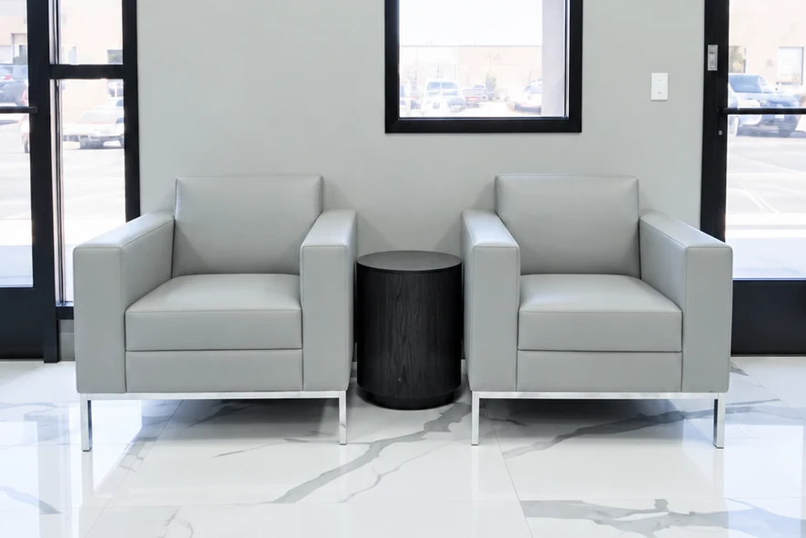 Reception seating beside tall storefront windows above the new marble-look tile floor.