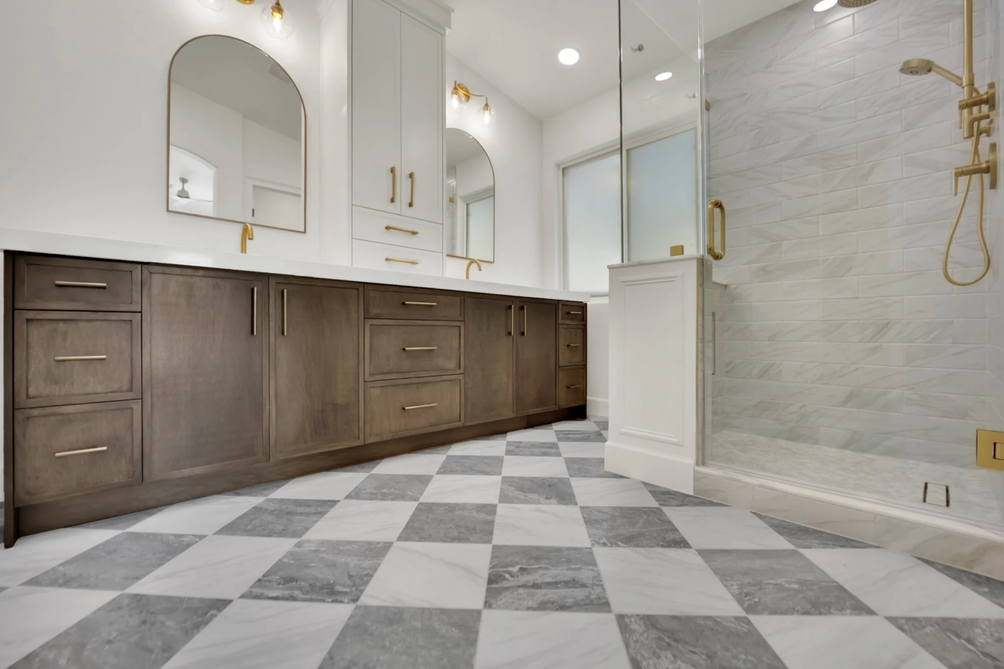 Primary bathroom remodel with marble floor, custom glass shower, white oak vanity, quartz top, and gold fixtures