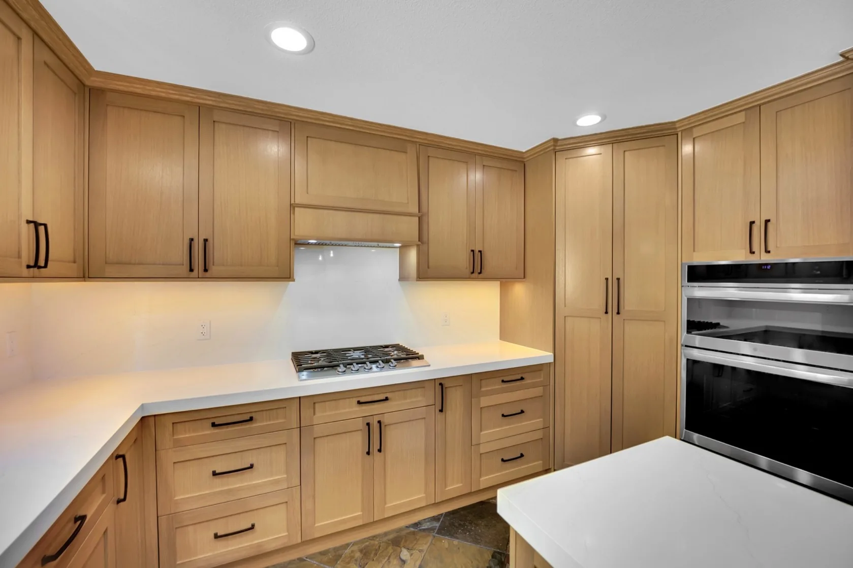 Finished rift white oak cabinet wall with Cambria quartz surfaces and built-in appliances