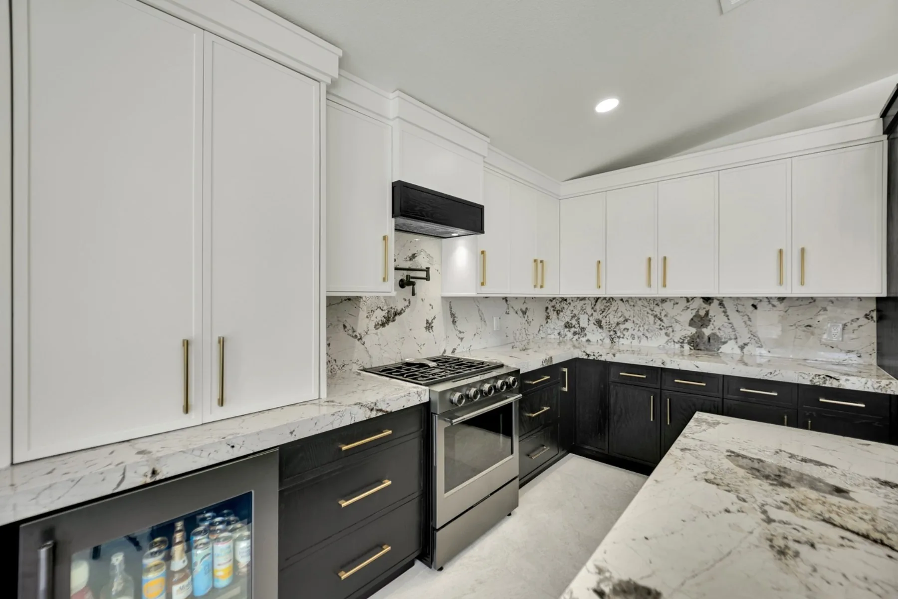 Hidden appliance garage and cooktop wall with granite slab backsplash in custom Las Vegas kitchen remodel