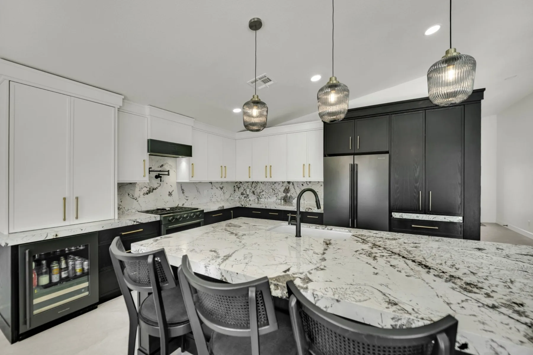 Summerlin custom kitchen remodel with painted white oak cabinets, cream upper cabinets, granite island, and brass hardware
