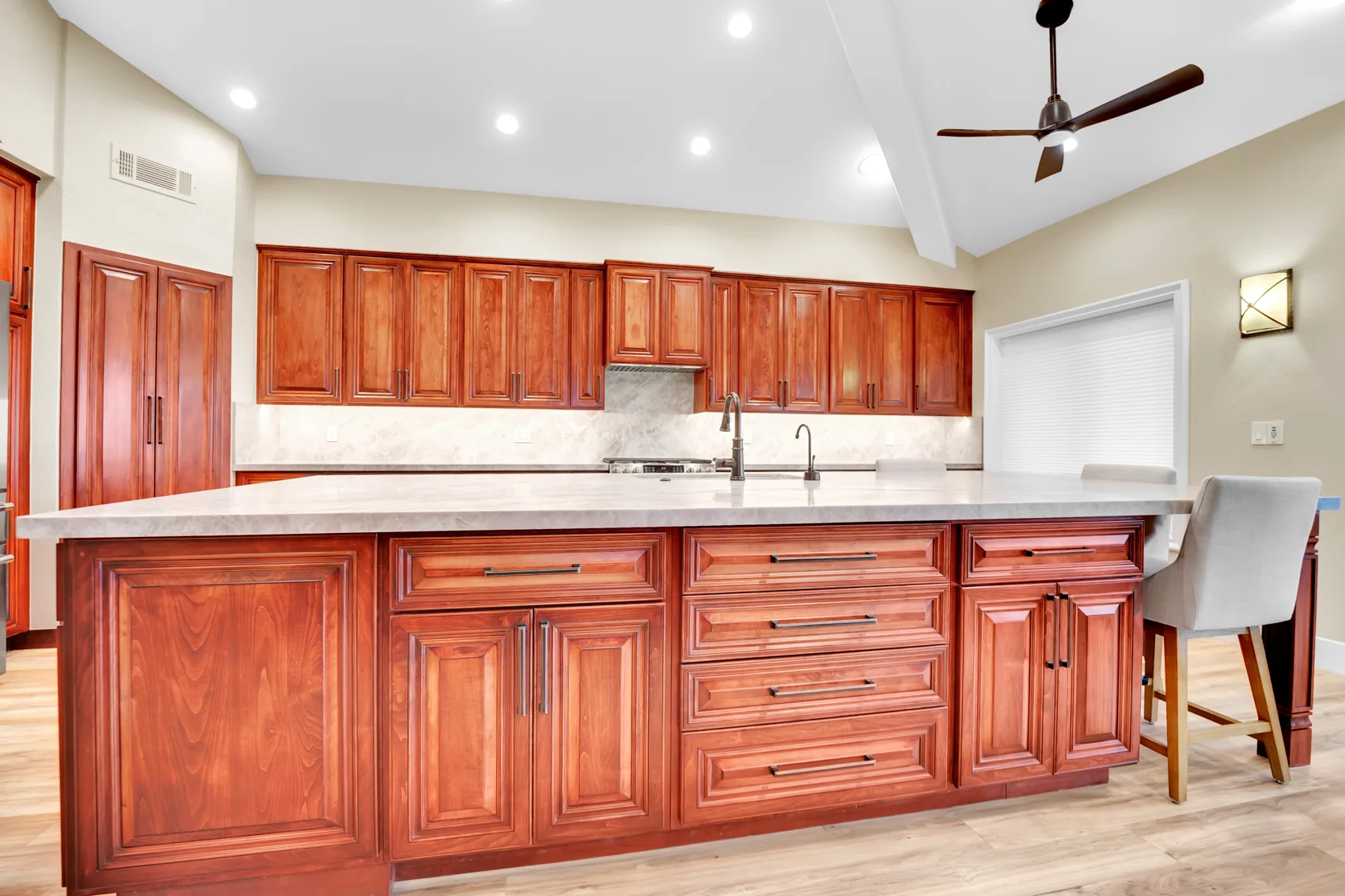 Custom maple kitchen remodel with 16-foot island and leathered Taj Mahal slabs