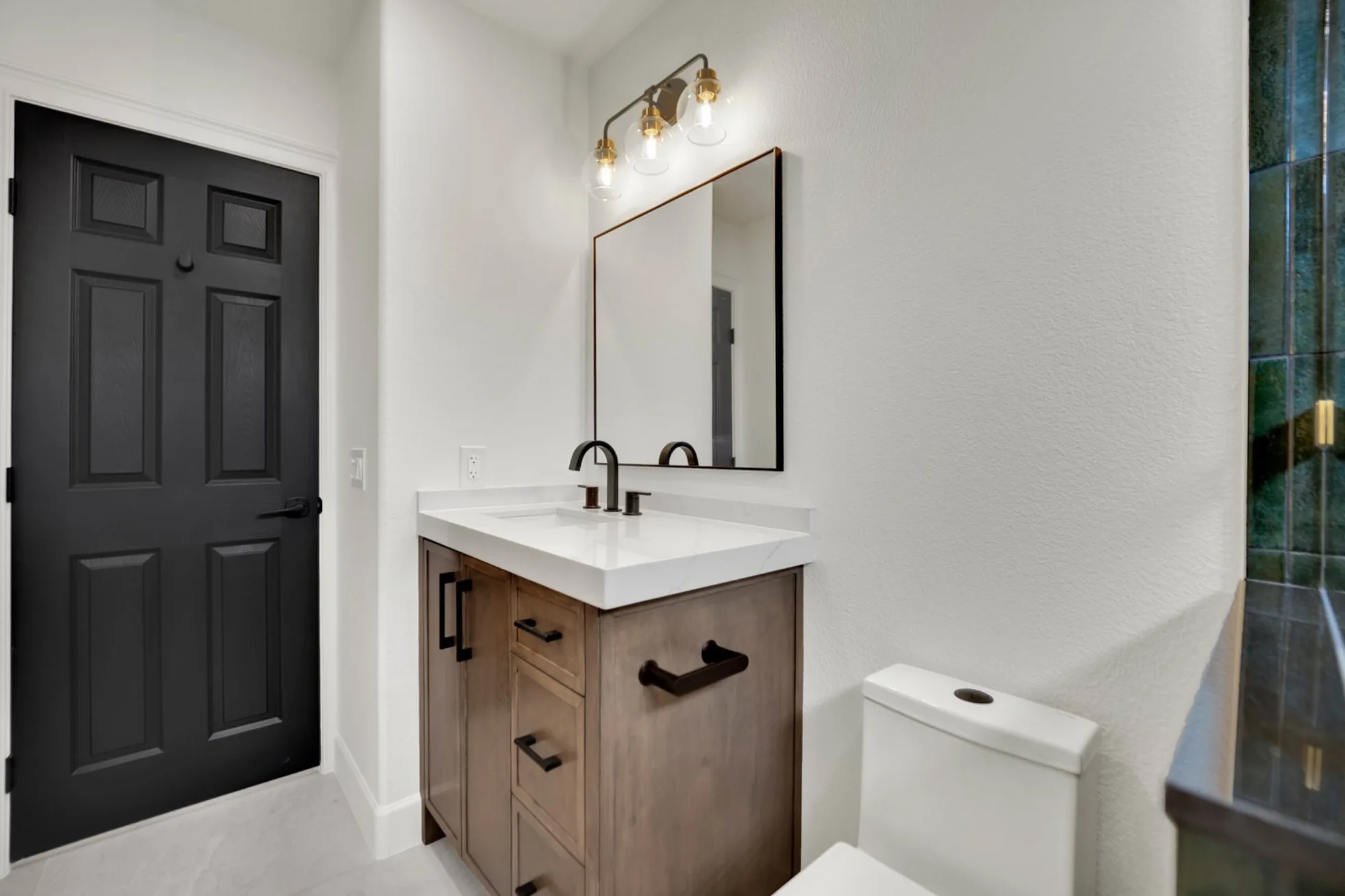 Custom wood bathroom vanity with quartz countertop, black fixtures, rectangular mirror, and semi-gloss painted walls