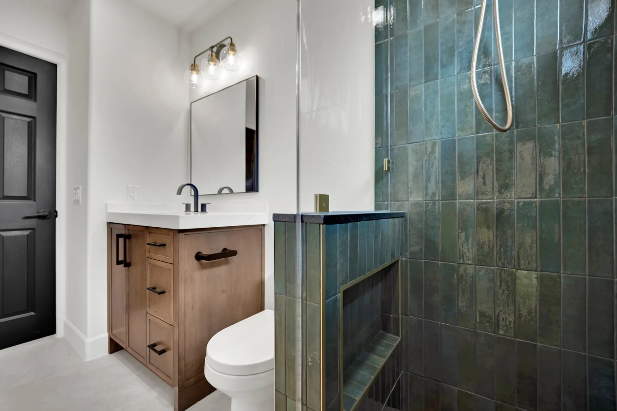 Finished secondary bathroom with walk-in shower, custom glass, Moroccan-style ceramic tile, custom wood vanity, quartz countertop, and large-format floor tile